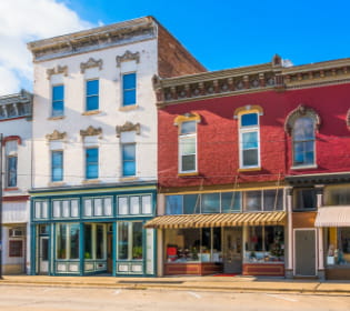 two Downtown store fronts one building white one building red 